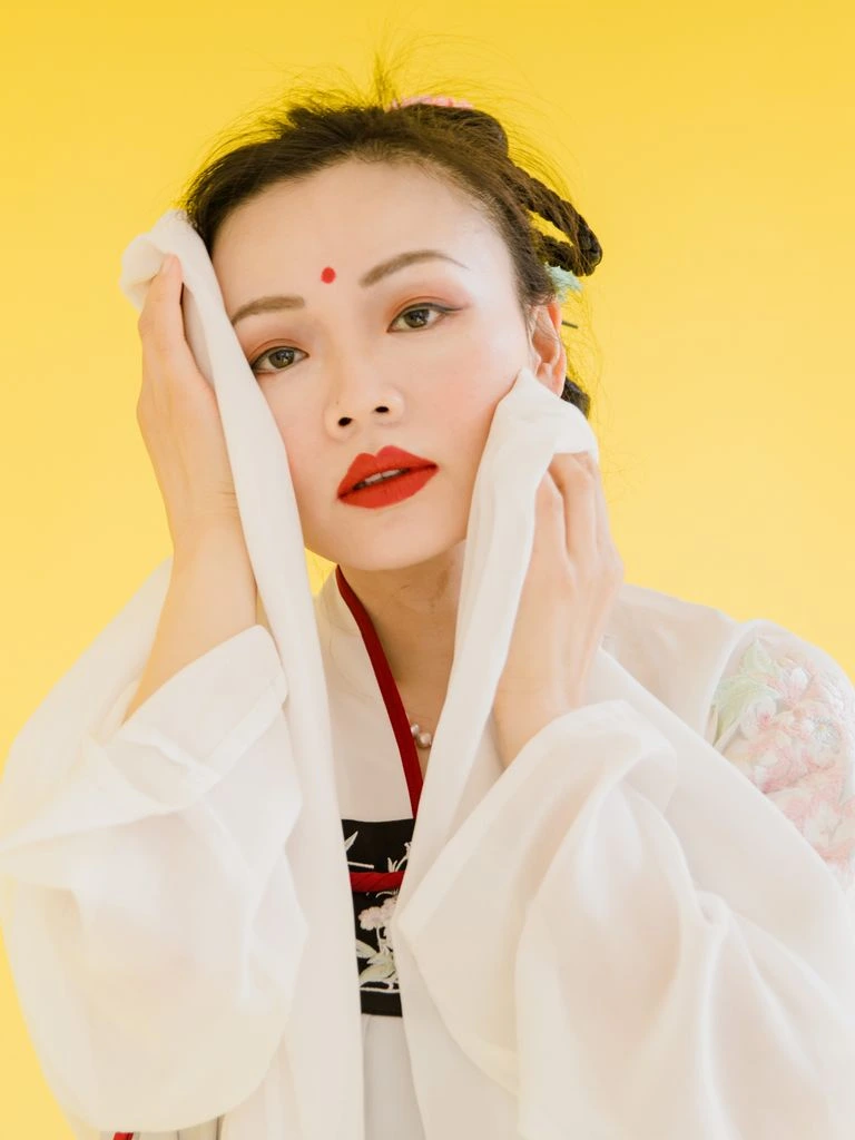 A Hanfu craftsperson at the Suzhou mill, embroidery frame in hand.
